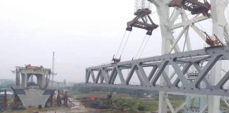 পদ্মাসেতুর ৩৮তম স্প্যানে ডাঙ্গা ও নদীর সংযোগ ঘটাচ্ছে; একটি খুঁটি পানিতে অন্যটি ডাঙায়