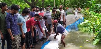 মুন্সীগঞ্জ-মাওয়া মহাসড়কে কনকসারে রাস্তার পাশে বালুর বস্তা ফেলে পানি আটকানোর চেষ্টা